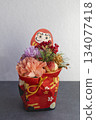A Japanese-style New Year's arrangement of auspicious Daruma dolls and flowers captured vertically 134077418