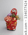 Vertical New Year's decorations featuring Daruma dolls and carnations that stand out against a bright background 134077424