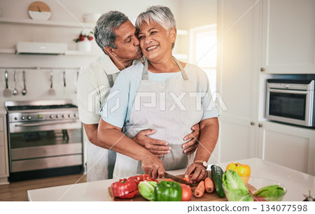Cooking vegetables, hug and elderly couple with kitchen ingredients, prepare food or smile on romantic home date. Nutritionist, marriage love and hungry man, woman or people bonding over healthy meal 134077598