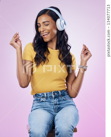 Music, headphones and Indian woman dance on pink background listening to track, audio and radio. Relax, happy and isolated girl singing streaming song for dancing, chilling and happiness in studio Music, headphones and Indian woman dance on pink background listening to track, audio and radio. Relax, happy and isolated girl singing streaming song for dancing, chilling and happiness in studio 134077713