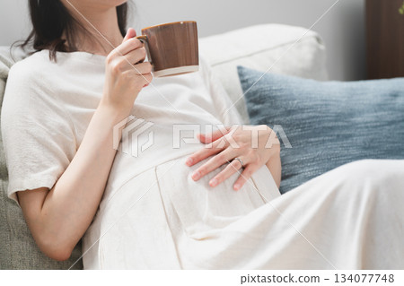 孕婦在沙發上喝飲料生活風格形象 孕婦在沙發上喝飲料生活風格形象 134077748