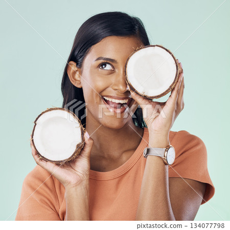 Beauty, face and happy woman with studio coconut for natural skincare, organic cosmetics or eco friendly makeup. Vitamins, health benefits and excited female with fruit product on green background 134077798