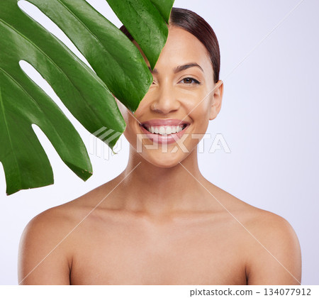 Portrait, leaf and woman in studio for skincare, dermatology and cosmetic on purple background. Beauty, face and girl model relax, smile and happy with glowing skin, cosmetology or monstera treatment Portrait, leaf and woman in studio for skincare, dermatology and cosmetic on purple background. Beauty, face and girl model relax, smile and happy with glowing skin, cosmetology or monstera treatment 134077912