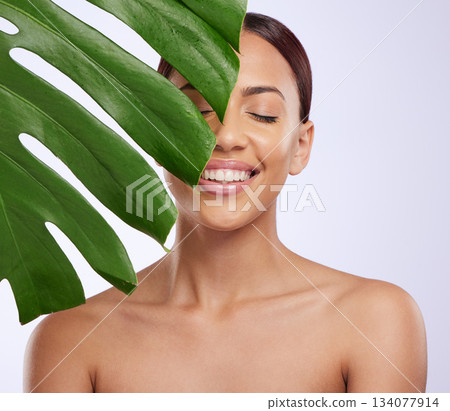 Smile, leaf and woman in studio for skincare, dermatology and cosmetic on purple background. Beauty, face and girl model relax, calm and happy with glowing skin, cosmetology or monstera treatment Smile, leaf and woman in studio for skincare, dermatology and cosmetic on purple background. Beauty, face and girl model relax, calm and happy with glowing skin, cosmetology or monstera treatment 134077914