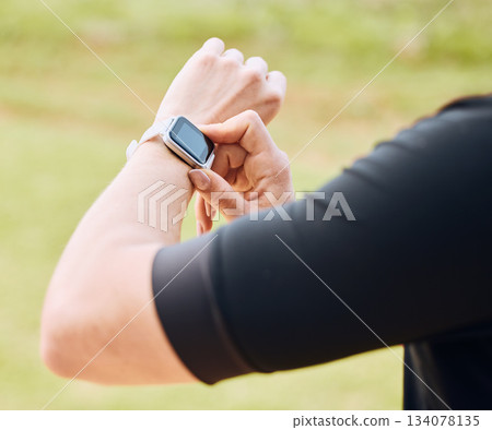 Hands, fitness and smart watch with a sports person outdoor, checking the time during a workout. Arm, exercise and technology with an athlete tracking cardio or endurance performance while training 134078135