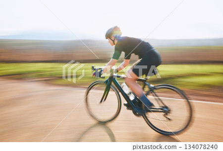Bicycle, ride outdoor and person on a bike with speed for sports race on a gravel road. Fitness, exercise and fast athlete doing sport training in nature in a park for cardio and healthy workout Bicycle, ride outdoor and person on a bike with speed for sports race on a gravel road. Fitness, exercise and fast athlete doing sport training in nature in a park for cardio and healthy workout 134078240