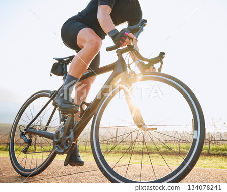 Bicycle, ride outdoor and person on a bike with travel for sports race on a vineyard gravel road. Fitness, exercise and fast athlete doing sport training in nature on a trail for cardio and workout Bicycle, ride outdoor and person on a bike with travel for sports race on a vineyard gravel road. Fitness, exercise and fast athlete doing sport training in nature on a trail for cardio and workout 134078241