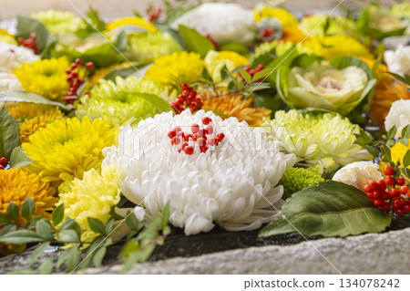 Auspicious red berries and colorful chrysanthemums floating in the water basin 134078242