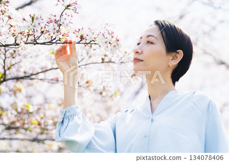 年輕女子看著櫻花花瓣生活方式圖像 134078406