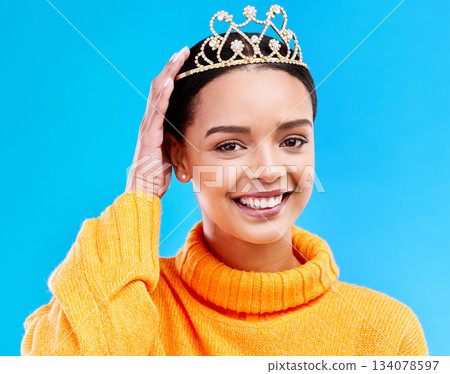Pride, crown and portrait of woman in studio for celebration, princess and party. Smile, beauty and fashion with female and tiara on blue background excited for achievement, winner and prom event 134078597