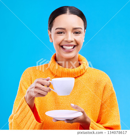 Tea, woman portrait and smile in studio with happiness, latte or matcha mug. Isolated, blue background and happy female model or young person smiling with casual winter fashion, joy and coffee drink 134078617
