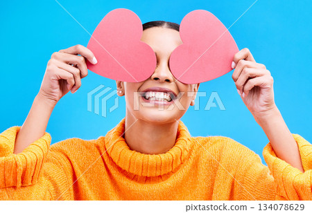 Heart eyes, cover and woman with happiness and excited about love, valentines day or emoji. Happy, smile and person with isolated blue background, loving or creative romance paper symbol to show care 134078629