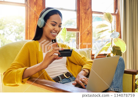 Woman, laptop and credit card with ecommerce and headphones to listen to music while online shopping. Happy female relax at home, podcast or radio streaming with fintech, internet banking and payment Woman, laptop and credit card with ecommerce and headphones to listen to music while online shopping. Happy female relax at home, podcast or radio streaming with fintech, internet banking and payment 134078759