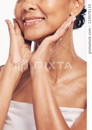 Hands, mouth and skin with a senior woman in studio for beauty, anti aging treatment or cosmetics. Skincare, facial and wellness with a mature female moisturizing her face for hydration closeup Hands, mouth and skin with a senior woman in studio for beauty, anti aging treatment or cosmetics. Skincare, facial and wellness with a mature female moisturizing her face for hydration closeup 134079110