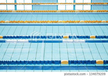 Empty, swimming pool or lines in water for competition or racing lanes for fitness or underwater sports. Background, blue or training arena ready for race performance, workout or exercise challenge Empty, swimming pool or lines in water for competition or racing lanes for fitness or underwater sports. Background, blue or training arena ready for race performance, workout or exercise challenge 134079209