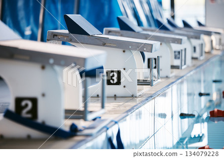 Start, platform and swimming with block at pool for championship, jumping and race. Fitness, competition and wellness with lane in indoor arena for exercise, workout and water sports training 134079228