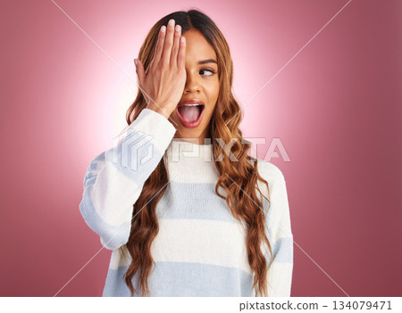 Hand, woman and cover eye with surprise, excitement and facial expression against a studio background. Female, joy and lady with shock, confident and playful with smile, goofy and humor with fun Hand, woman and cover eye with surprise, excitement and facial expression against a studio background. Female, joy and lady with shock, confident and playful with smile, goofy and humor with fun 134079471