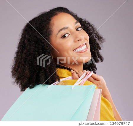 Woman, face and portrait smile with shopping bags for discount, sale or fashion against gray studio background. Happy female shopper smiling and holding gifts or shop accessories posing in happiness Woman, face and portrait smile with shopping bags for discount, sale or fashion against gray studio background. Happy female shopper smiling and holding gifts or shop accessories posing in happiness 134079747