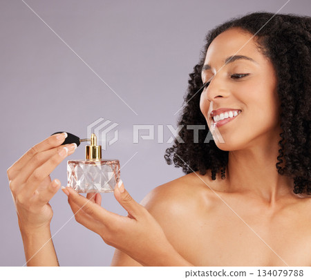 Beauty, self care and woman in a studio with perfume for a fresh scent, bodycare or wellness. Happy, smile and female model with bottle of fragrance for cosmetic health isolated by a gray background. 134079788