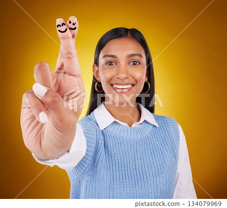 Smiley face, fingers crossed and portrait of Indian woman in studio with drawing for hand sign, symbol and luck. Emoji mockup, yellow background and happy girl smile for wish, hope and lucky gesture 134079969