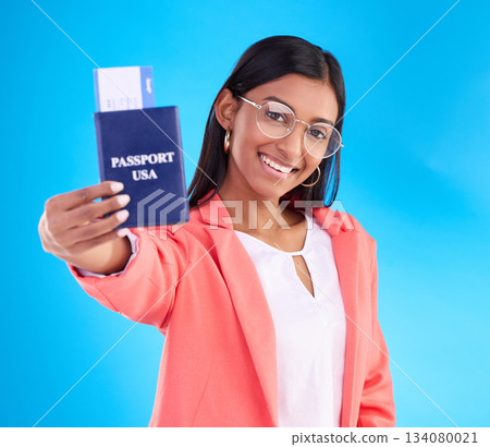 Happy woman, passport or ticket for travel, flight or USA documents against a blue studio background. Portrait of female business traveler smile holding international boarding pass or booking trip Happy woman, passport or ticket for travel, flight or USA documents against a blue studio background. Portrait of female business traveler smile holding international boarding pass or booking trip 134080021