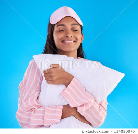 Sleep, happy and a woman hugging a pillow isolated on a blue background in a studio. Smile, comfy and a girl ready for sleeping, nap or slumber in pyjamas for comfort and coziness on a backdrop 134080070