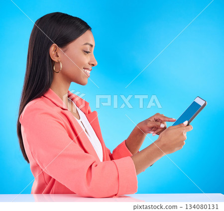 Happy woman, tablet and smile for research, social media or browsing and communication against a blue studio background. Female employee working on touchscreen for business data or search on mockup Happy woman, tablet and smile for research, social media or browsing and communication against a blue studio background. Female employee working on touchscreen for business data or search on mockup 134080131