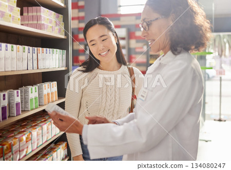 Dispensary, medication or prescription with a pharmacist and asian woman customer talking about a product. Healthcare, consultant and a medicine professional talking to a happy female in a pharmacy Dispensary, medication or prescription with a pharmacist and asian woman customer talking about a product. Healthcare, consultant and a medicine professional talking to a happy female in a pharmacy 134080247