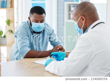Doctor, covid and black man in consultation for results on clipboard in hospital. Healthcare, face mask and medical professional with paperwork talking with patient for health diagnosis or checkup. Doctor, covid and black man in consultation for results on clipboard in hospital. Healthcare, face mask and medical professional with paperwork talking with patient for health diagnosis or checkup. 134080354