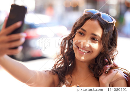 Woman, city and selfie with bag, sale and smile for fashion, discount and social network app in summer. Gen z influencer girl, smartphone photography and profile picture with shopping on urban street Woman, city and selfie with bag, sale and smile for fashion, discount and social network app in summer. Gen z influencer girl, smartphone photography and profile picture with shopping on urban street 134080391