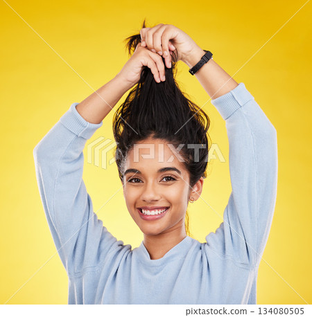 Young woman, haircare and playful, smile in portrait and hair in air with gen z and fashion on yellow studio background. Happiness, youth and silly Indian female, happy with growth with shine Young woman, haircare and playful, smile in portrait and hair in air with gen z and fashion on yellow studio background. Happiness, youth and silly Indian female, happy with growth with shine 134080505