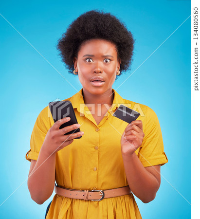 Black woman, phone and credit card with shock, portrait and wow face in studio by blue background. Surprise girl, african or smartphone on online shopping app, e commerce store or amazed for discount Black woman, phone and credit card with shock, portrait and wow face in studio by blue background. Surprise girl, african or smartphone on online shopping app, e commerce store or amazed for discount 134080560