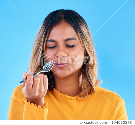 Woman, fork and cake in studio for eating dessert, satisfied or eyes closed for happiness by blue background. Model, girl and happy for sweets, snack or test flavor for food, meal or diet by backdrop 134080578