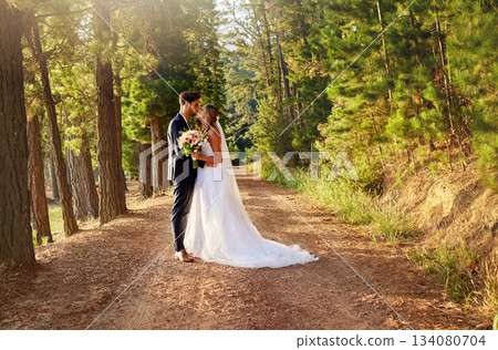 Wedding, married and couple kiss in forest, garden and nature for celebration of love, care and commitment. Bride, groom and kissing in park for romance, bridal event and celebrate marriage ceremony 134080704