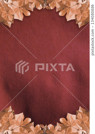 Dried brown and orange autumn leaves are framing flat design maroon textured backdrop 134080886