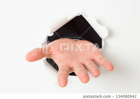 Open hand bursting through paper 134080942