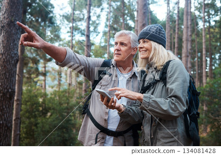 Senior couple, hiking and phone outdoor in nature for direction for exercise, fitness and trekking. Old man and woman with smartphone and hand on forest hike for workout, cardio and gps or compass 134081428