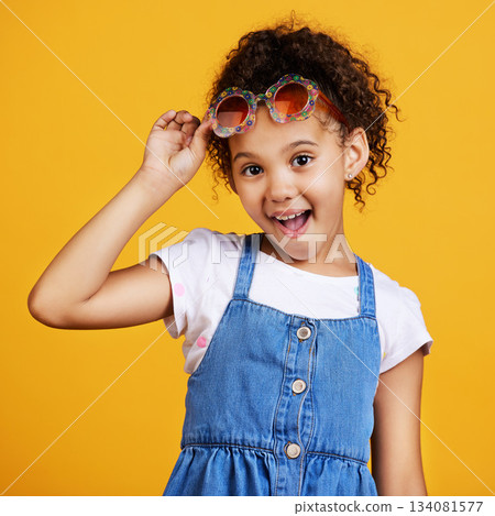 Girl child, smile and sunglasses in studio portrait for summer style or happy by yellow background. Mixed race model, female kid or fashion frame on face for surprise expression, eye care and youth Girl child, smile and sunglasses in studio portrait for summer style or happy by yellow background. Mixed race model, female kid or fashion frame on face for surprise expression, eye care and youth 134081577