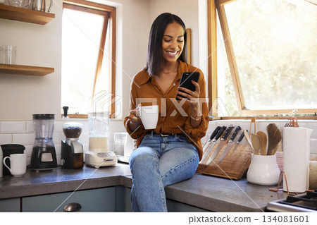 Smile, kitchen and woman with phone on coffee break while browsing internet, checking social media meme or reading email. Chat, connect and work from home lifestyle, latino freelance in apartment. Smile, kitchen and woman with phone on coffee break while browsing internet, checking social media meme or reading email. Chat, connect and work from home lifestyle, latino freelance in apartment. 134081601