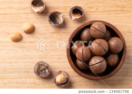 Macadamia nuts in a bowl on wooden background, Table top view Macadamia nuts in a bowl on wooden background, Table top view 134081798