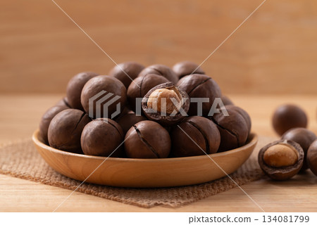 Macadamia nuts in a bowl on wooden background Macadamia nuts in a bowl on wooden background 134081799
