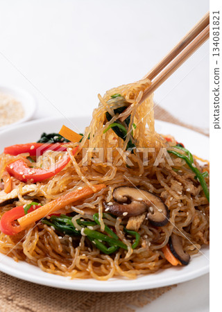 Japchae, Korean stir fried glass noodles with vegetables, pork, soy sauce and sesame seed 134081821