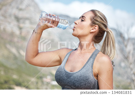 Fitness, woman and drinking water for hydration, workout or recovery break from running exercise in nature. Thirsty active female having natural drink to stay hydrated after intense cardio training 134081831