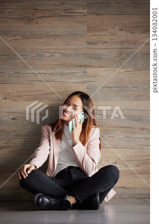 Young business woman, floor and phone call with smile for networking, discussion and talk in modern office. Professional female, smartphone and listen for conversation, chat and space for mock up 134082001