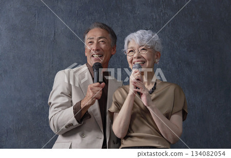 老年男女在黑色背景下唱卡拉OK 134082054