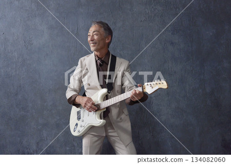 Senior man playing electric guitar black background Senior man playing electric guitar black background 134082060