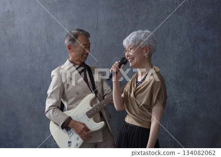 Senior musicians: male guitarist and female vocalist, black background Senior musicians: male guitarist and female vocalist, black background 134082062