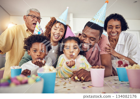 Birthday party, blow and confetti with family in kitchen for celebration, bonding and affectionate. Happy, excited and grandparents with parents and children at home for surprise, fun or event 134082176