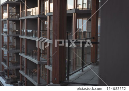 Flat design is showing multi story balcony facade with glass railings, tiled floor, snow on ground 134082352