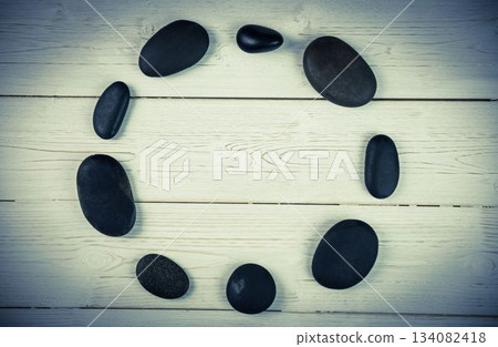 Black pebbles on wooden flooring 134082418